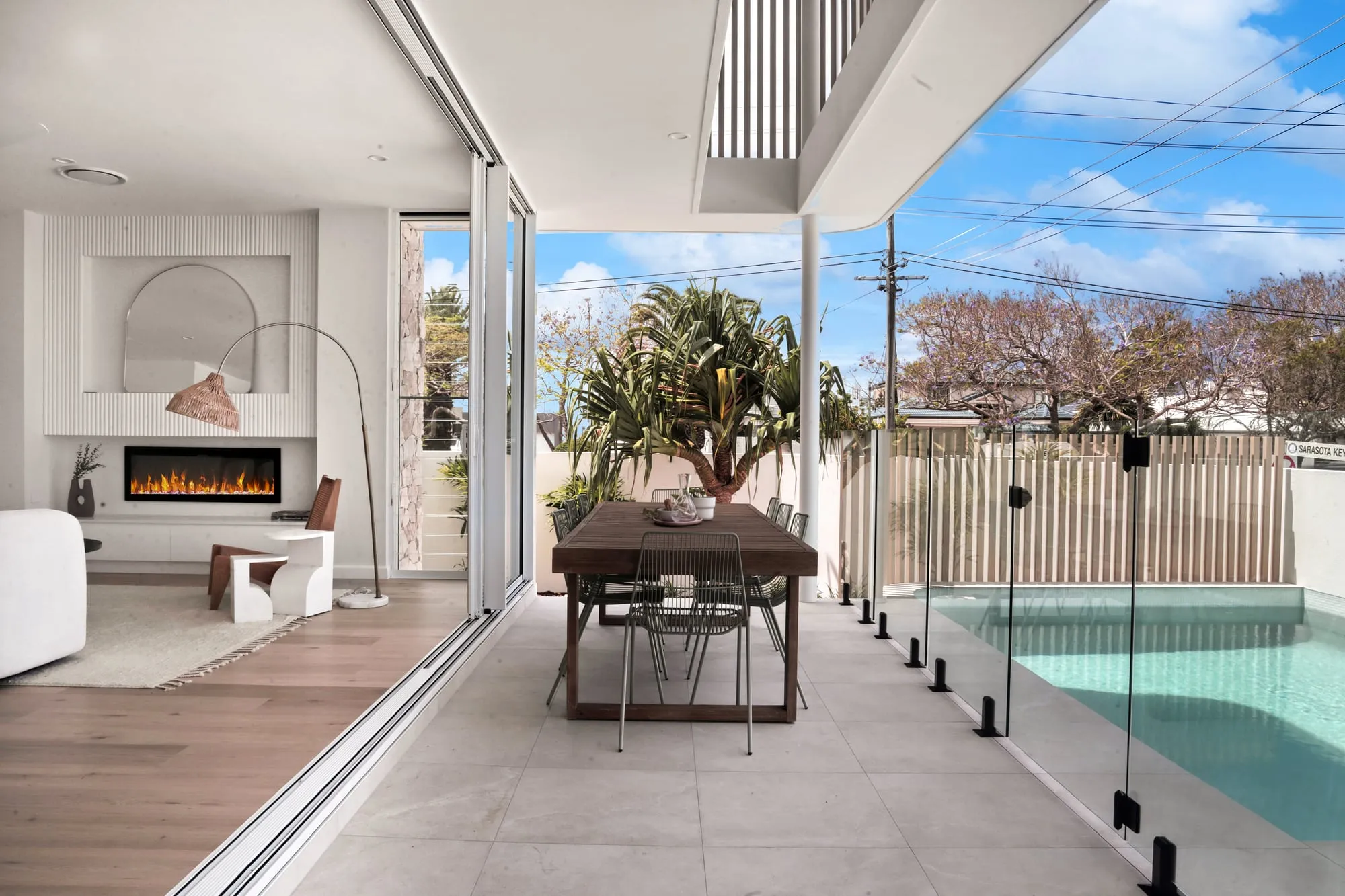 Open-plan living and dining opening through full-height sliding doors to the pool