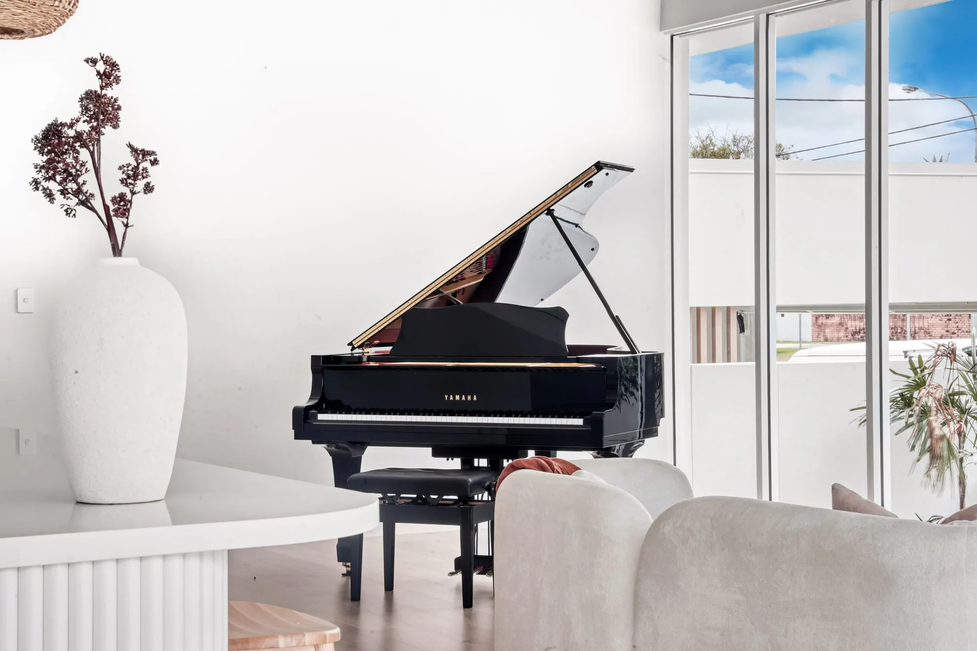 Grand piano in the living area beside the kitchen island