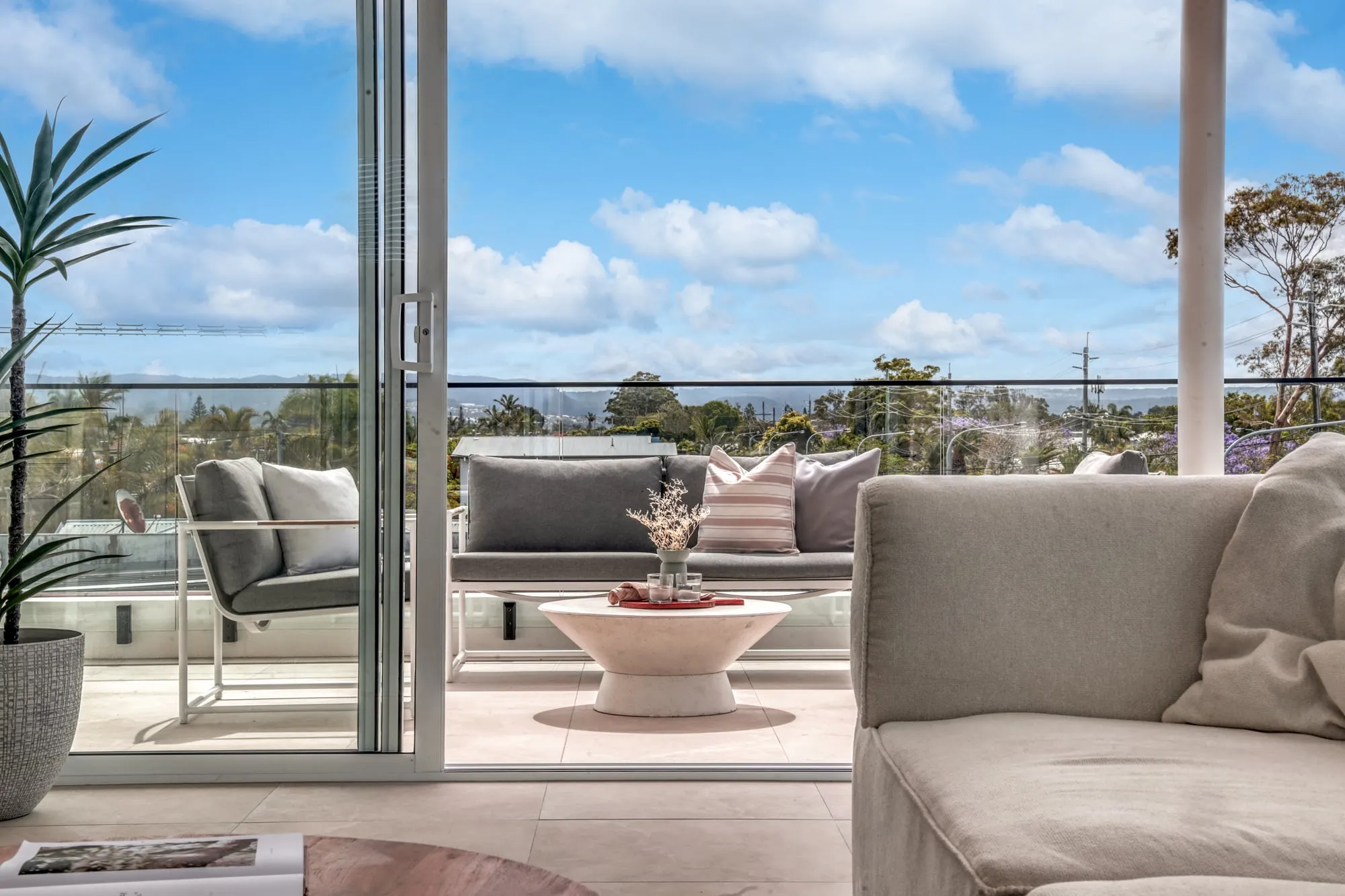 Covered terrace with outdoor lounge seating, seen from the living room